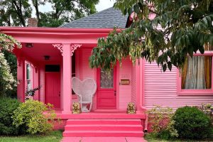 A weatherboard house painted in a pink exterior, inspiration for a barbiecore themed color palette.