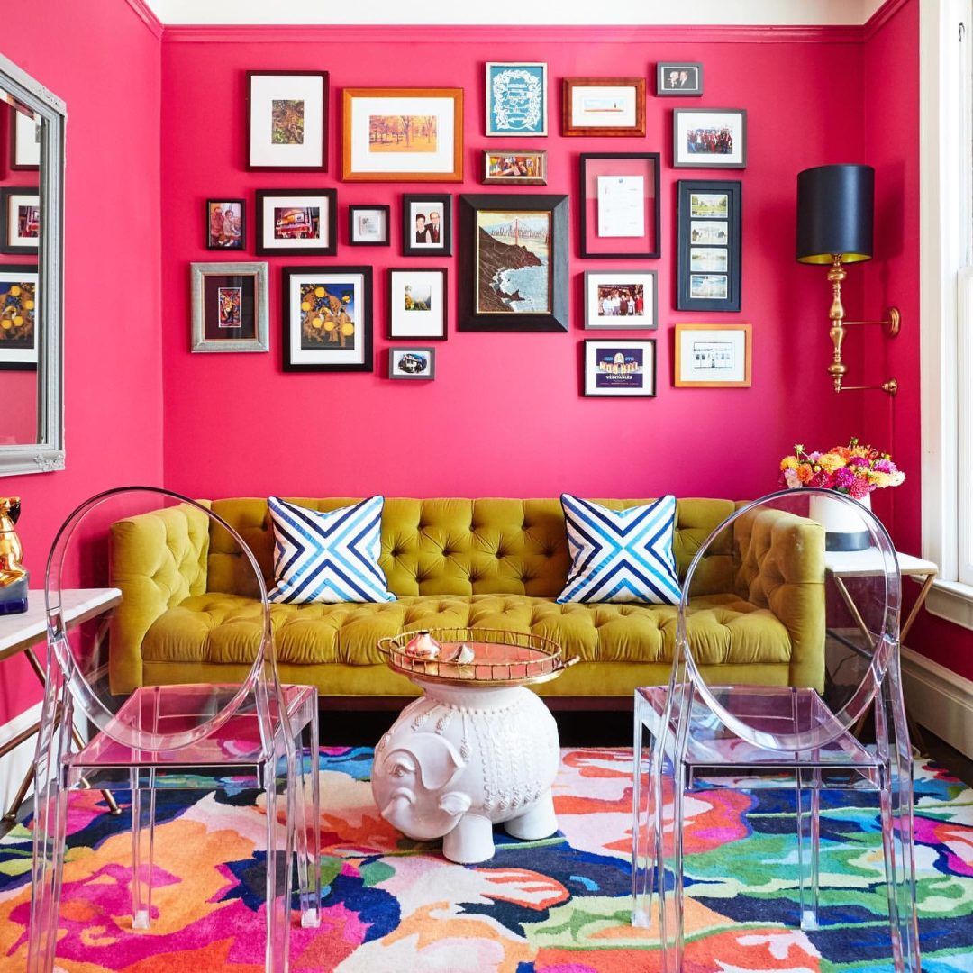 A room with eclectic decorations, mustard sofa, bright pink wall, inspiration for a barbiecore interior.