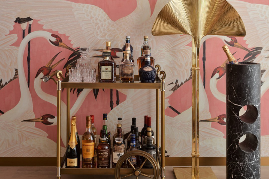 Inspiration for a barbiecore interior, a cocktail drinks tray, against a pink wall, gold accessories.