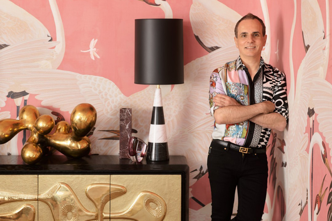 Greg Natale posing in a room with pink wallpaper, inspiration for a barbiecore interior.